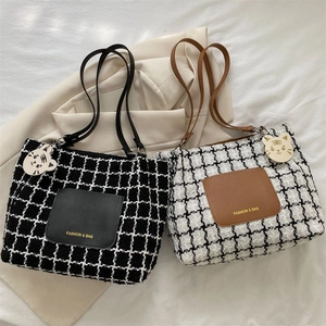 Détail du sac cabas en toile à carreaux avec poche en cuir et pendentif tigre mignon