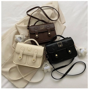 Detailed view of vintage small square bags in brown, black, and white with bear charms