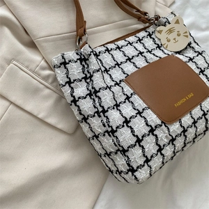 Détail du sac cabas en toile à carreaux avec poche en cuir marron et breloque tigre