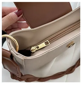 Detail view of the spacious inner compartment and smooth golden zipper of the bicolor bag