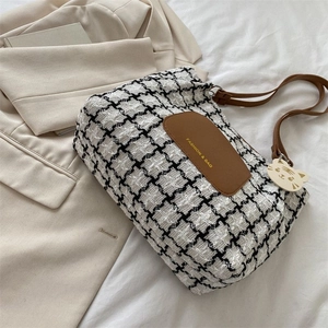 Détail du sac cabas en pied-de-poule avec étiquette en cuir marron et pendentif chat