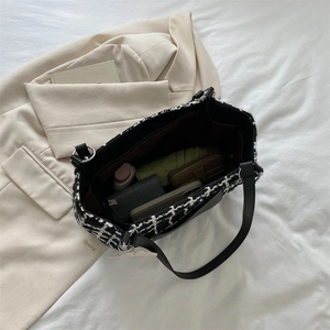 Vue de dessus du grand sac cabas en tweed noir et blanc montrant des compartiments spacieux