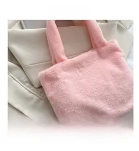 Close-up of pink faux fur tote bag showing soft plush texture on a white blazer background