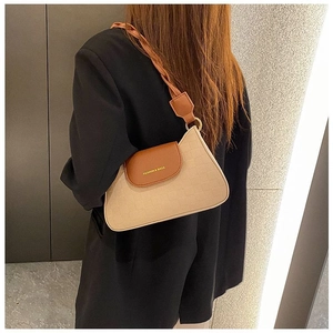 Close-up of contrast crossbody bag with woven strap and gold fashion lettering