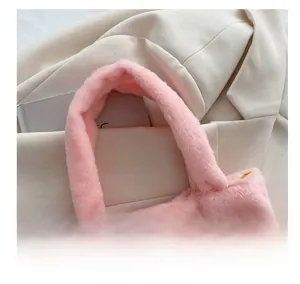 Close-up of a plush pink handbag featuring a soft faux fur handle and cozy fluffy texture