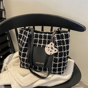 Détail du sac cabas en toile à carreaux avec poche en cuir et breloque tigre mignon