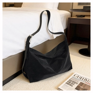 Detail of adjustable metal buckle on a black hobo shoulder bag with matte nylon texture