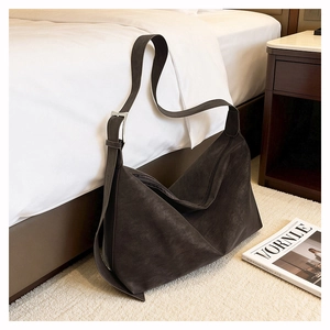 Detail of adjustable silver buckle and matte suede texture on a large tote bag