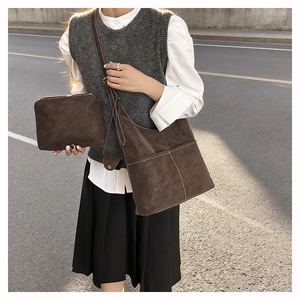 Detail view of retro brown tote bag and matching pouch with white stitching details