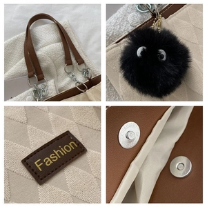 Dettagli della borsa tote in maglia beige con manici in pelle marrone e ciondolo peluche