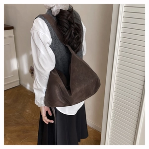 Detail view of large dark brown hobo bag with vintage matte texture worn by a model