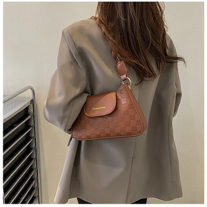 Close-up of brown retro underarm bag with checkered texture and fashion text print