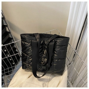 Detail view of black quilted space cotton tote bag with glossy nylon and wide straps