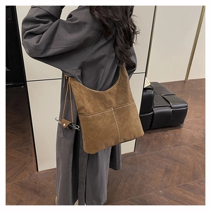 Detail of dark brown matte tote bag with white contrast stitching on minimalist model