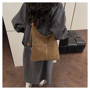 Macro view of brown matte suede tote bag featuring distinctive white vertical stitching details