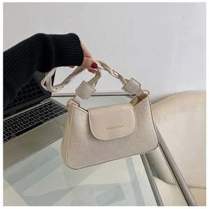 Close-up of beige woven handle handbag with quilted checkerboard pattern and gold text