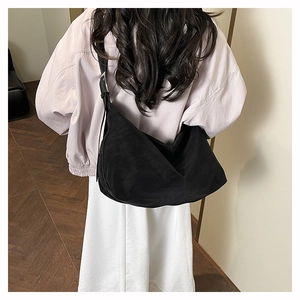 Dettaglio della borsa hobo nera con texture in camoscio opaco e fibbia argentata
