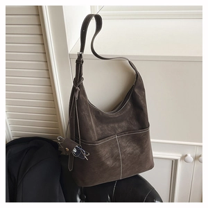 Detail of dark brown suede tote bag with white contrast stitching and a mini pouch