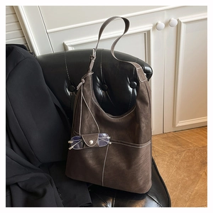 Detail of dark brown matte tote bag featuring a convenient leather glasses holder loop