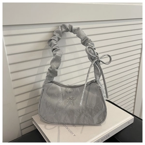 Detail of silver marble-textured bag with scrunchie handle and butterfly bow accent