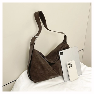 Detail showing large capacity of the brown hobo bag fitting a tablet and smartphone