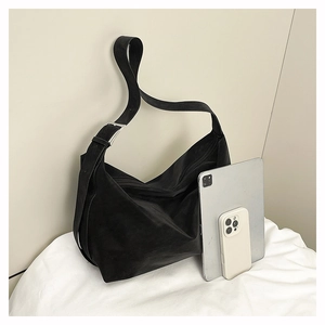 Detail view of large black tote bag with wide strap and tablet for size comparison