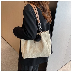 Dettaglio della borsa tote trapuntata bianco off-white con catena e pompon nero