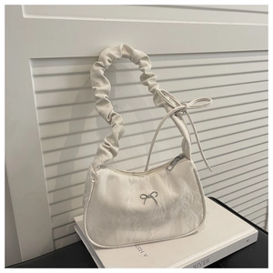 Detail of cream pleated underarm bag with silver bow buckle and marbled texture