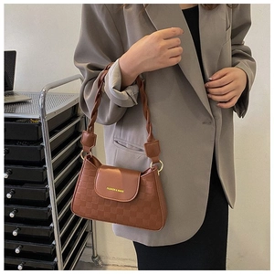 Detailed view of brown faux leather shoulder bag with woven strap and checkered pattern