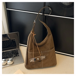 Detail of dark brown matte tote bag with contrast stitching and small eyewear pouch charm