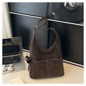 Detail of deep brown frosted tote bag showing white contrast stitching and outer pockets
