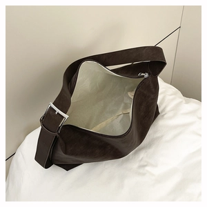 Detail of dark brown semi-moon shoulder bag showing spacious interior and silver buckle