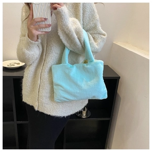 Light blue plush handbag styled with a cream cardigan and black trousers for daily wear