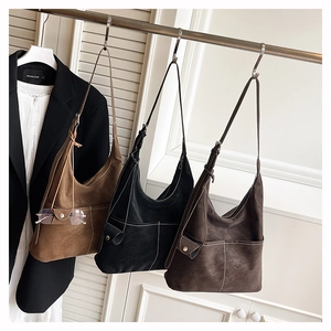 Close-up of retro hobo bags with white contrast stitching and soft matte texture