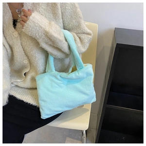 Detailed close-up of mint green plush handbag texture and soft faux fur material