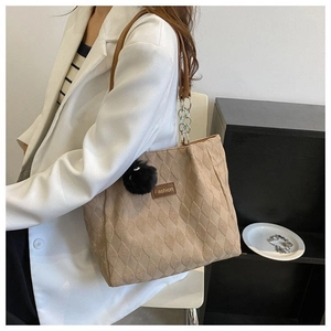 Dettaglio borsa shopper trapuntata kaki con toppa Fashion e ciondolo a pompon nero