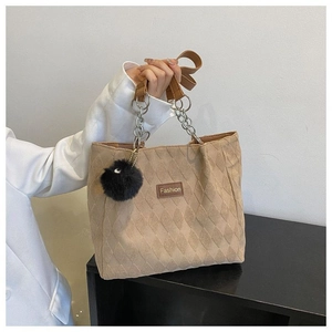 Dettaglio della borsa tote trapuntata beige con ciondolo di peluche ed etichetta