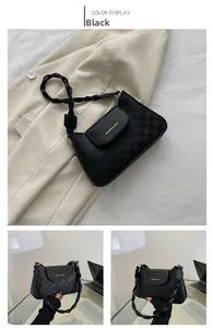 Detail of black checkerboard shoulder bag with woven handle on a beige blazer