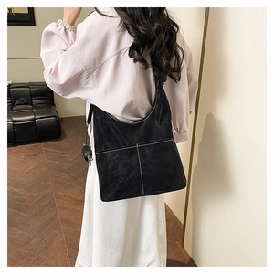 Detail showing the white stitching on a black frosted leather tote bag for daily commute