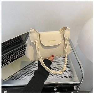Close-up of off-white checkered handbag featuring a thick braided handle and text