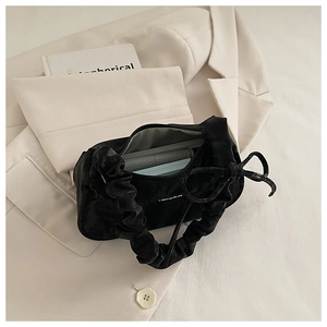 Inside view of black pleated shoulder bag showing daily items and storage capacity