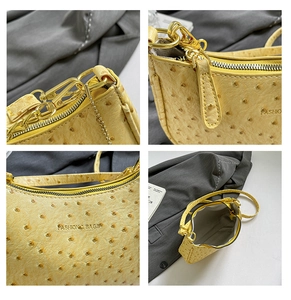 Detail view of yellow ostrich texture crescent bag with gold zipper and chain strap
