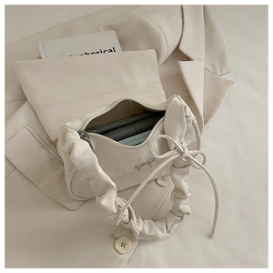 Detail view of the beige glossy handbag interior showing capacity for phone and wallet