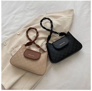 Detail of trendy checkered embossed shoulder bags with woven handles on ivory coat