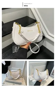Detail of white ostrich texture handbag with golden chain and fashion logo print