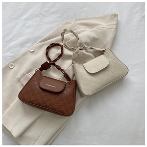 Detail of checkered embossed shoulder bags in brown and beige with woven handles