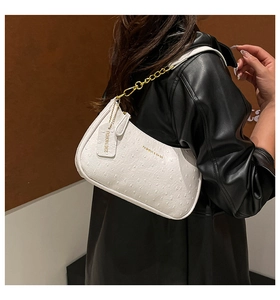 Detail of white ostrich texture handbag with gold chain strap and fashion logo