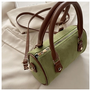 Detail of vintage Boston bag with olive suede texture, brown leather handles and gold zippers