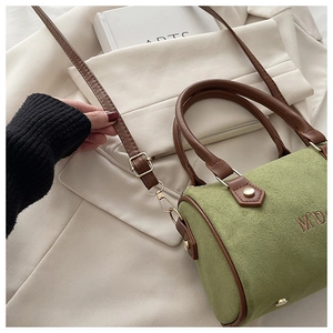Detail of green suede Boston bag with brown leather handles and M'D embroidery detail