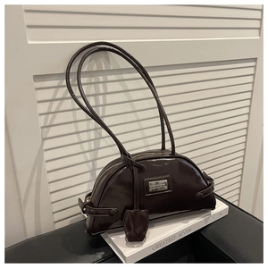 Detailed view of dark brown semi-circle shoulder bag with glossy oil-wax leather texture